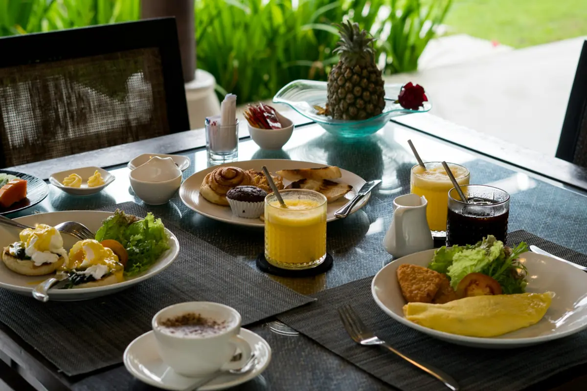 Colazione servita a un tavolo d’albergo: uova, dolci da forno, frutta e caffè