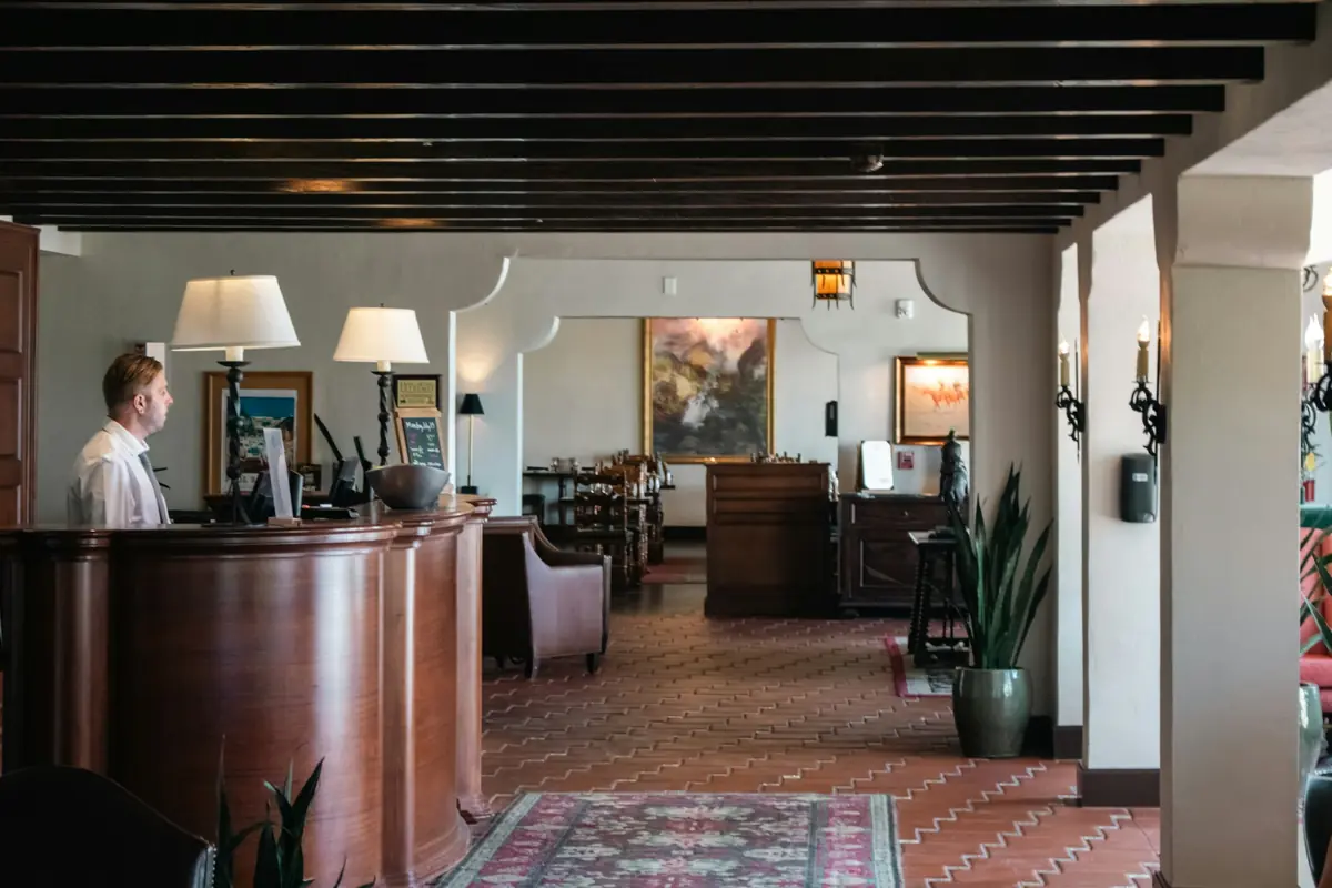 Un membro del personale alla reception di un piccolo hotel